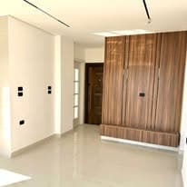 Hallway with walnut panelling, concealed lighting, and a solid interior door